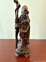 Full view of the carved rosewood statue showing Shou Lao standing with staff on a carved base.