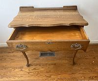 Top and front view of the antique tiger oak hall table with drawer open, showing carved wood detail and wood grain.
