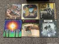 Photo of six LP record album covers arranged in two rows of three on a carpeted floor.