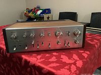 Front view showing silver control panel, knobs, switches and wood veneer sides