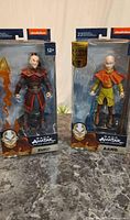 Two packaged action figures of Zuko and Aang from Avatar: The Last Airbender, side by side on a surface.