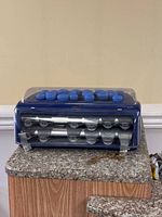 Hair rollers set in blue plastic display case with clear lid, showing 20 rollers on top and inside the case.