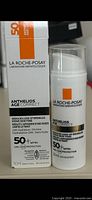 Front of boxed product and bottle showing label for La Roche-Posay Anthelios Age Correct SPF 50 anti-aging cream.