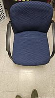 Top view of a blue fabric office chair showing seat, backrest, and armrests
