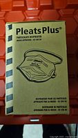 Photo of front of Pleats Plus particulate respirator mask box, showing brand name, particulate respirator description and NIOSH approval 42 CFR 84.