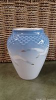 Porcelain vase with blue to white gradient, raised scale pattern, and seagulls on the body.