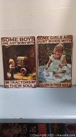 Two vintage-style metal signs side by side, one with a boy and tractors theme, the other with a girl and colors theme.