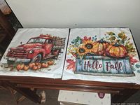 Photo showing two fall-themed decorative pillow covers, one with a red truck and pumpkins and the other with pumpkins, sunflowers, and 'Hello Fall' text.