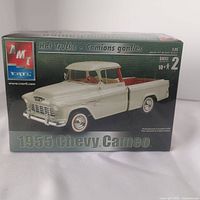 Box front showing detailed model of 1955 Chevy Cameo truck with white body and red interior.