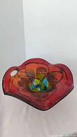 Top view of art glass vase/dish showing colorful abstract pattern and red edges