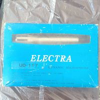 Blue box labeled Electra UD-117 dynamic microphone showing the outside packaging with specifications and wear.