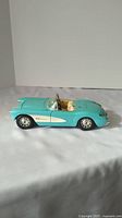 Side profile of turquoise Burago 1/18 scale Chevy Corvette model highlighting the overall shape and body color.
