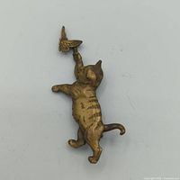 Front view of cat brooch holding butterfly on spring showcasing movement feature.