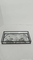 Full view of the rectangular glass container showing the black metal frame and clear glass sides with the embossed atlas map on the bottom panel.
