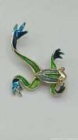 Front view of green enamel frog brooch showing color details and design
