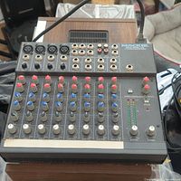 Top view of Mackie 12 channel 1202 audio mixer showing all input jacks, knobs, and level meters.