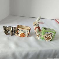 Front view of donkey and rabbit small ceramic planters with carts
