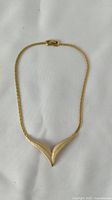 Full view of the vintage D'Orlan gold tone necklace laid flat on a white background.