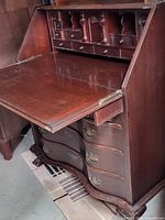 Open fold-down writing surface showing multiple small drawers and compartments inside the secretary desk.