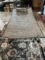 Full view of large fabric hammock stretched on adjustable metal frame showing wooden handles and attached pillow