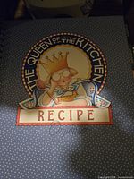 Cover of 'The Queen of the Kitchen Recipe Organizer' book with blue polka dot background and cartoon queen illustration