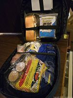 Photo showing contents of the Sub Zero medical car kit including emergency blanket, bandages, gloves, and other first aid materials in a black zippered case.