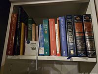 Shelf view of religious and spiritual books including Bible trivia, church history, Siddur volumes, Daily Guideposts, and faith books.