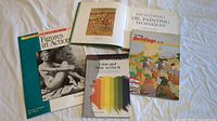 Five art books arranged on a surface including Figures in Action, Encyclopedia of Oil Painting Techniques, Color and How to Use It, Buildings in Art, and another art book with a green hard cover.