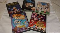 Five DVD cases laid out showing titles and artwork from Family Guy and Futurama animated shows and movies.