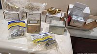Photo shows multiple plumbing valves and actuators in original boxes and bags on counter.