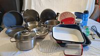 Full view of assortment of pots, pans, baking trays, plastics and utensils.