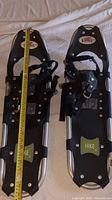 Pair of Redfeather snowshoes laid flat, showing full length with measuring tape confirming 30 inches.