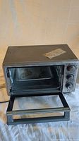 Oster toaster oven with door open showing interior and control knobs