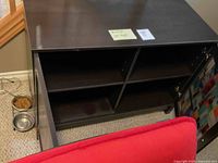 Top view of cabinet opened showing two compartments each with two shelves inside, dark wood finish visible.