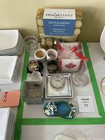 Full lot arrangement showing various votive candle holders, a 100-pack of Mainstays tea lights, and a maple leaf decorative candle.