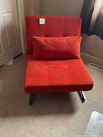 Red convertible chair with matching bolster pillow in upright chair position.