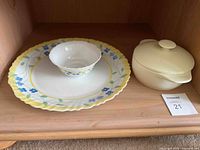 Photo of the Arcopal Feston large plate, small bowl, and cream-colored covered casserole dish displayed on a wooden shelf.