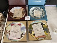 Four collector plates each in original box with certificates of authenticity revealing artist and title information