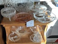 Front view of lot with 10 crystal and glass pieces arranged on wooden furniture