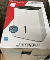 Frigidaire dehumidifier in its box showing front view with 50 pint capacity and Energy Star logo.