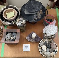 Overview of all items including water fountain rocks, candle holder, and containers of various rocks, showing lot collection