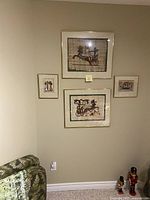 Four framed Egyptian papyrus prints mounted on a wall, showing various Egyptian scenes including chariots and figures.