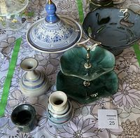 Photo showing blue and white ceramic tagine, decorative blue bowl with bird details, three vases in blue and green hues, two-tier green ceramic serving tray.