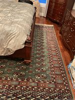 Rug laid under bed showing full field and border pattern