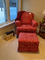 Front view of red armchair with matching ottoman and magazine rack