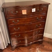 Full front view of mahogany chest of drawers showing overall shape and handles