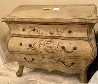 Front view of wood chest showing three drawers with floral design