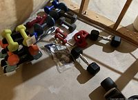 Wide shot of all dumbbells on floor and rack