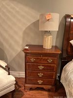 First mahogany end table with lamp on top, angle view showing drawers and finish
