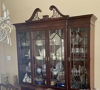 Front view of two-piece mahogany hutch and buffet in a dining room setting, showing glass doors and detailed woodwork.